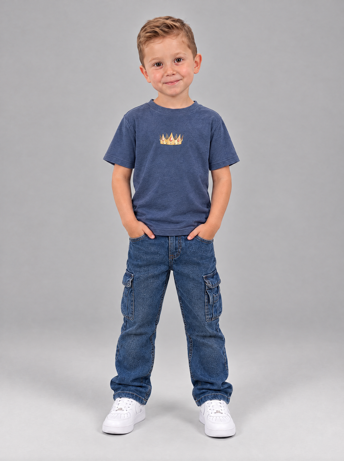 Junge im vintageblauen Jesus is King Kindershirt, Vorderseite mit goldener Krone