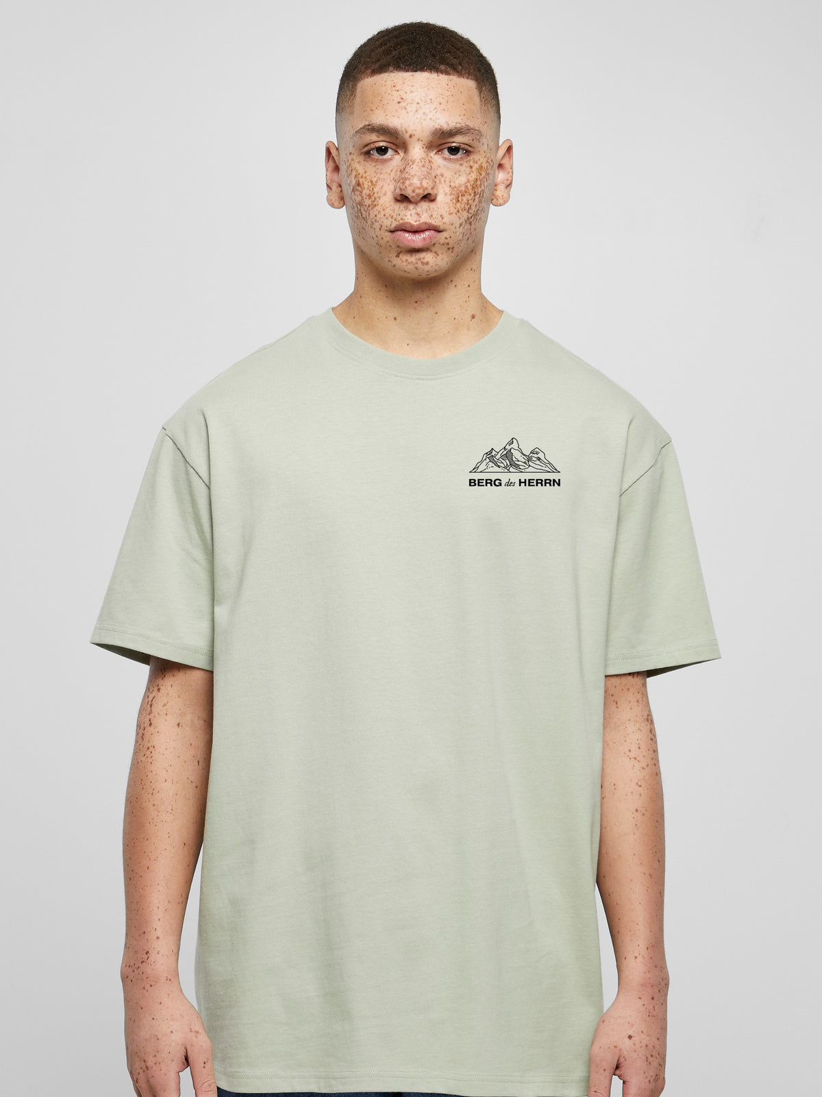 Mann im salbeigrünen Oversized T-Shirt Berg des Herrn