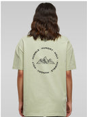 Frau von hinten im salbeigrünen Berg des Herrn Shirt mit Bergmotiv und Humble Hungry Holy
