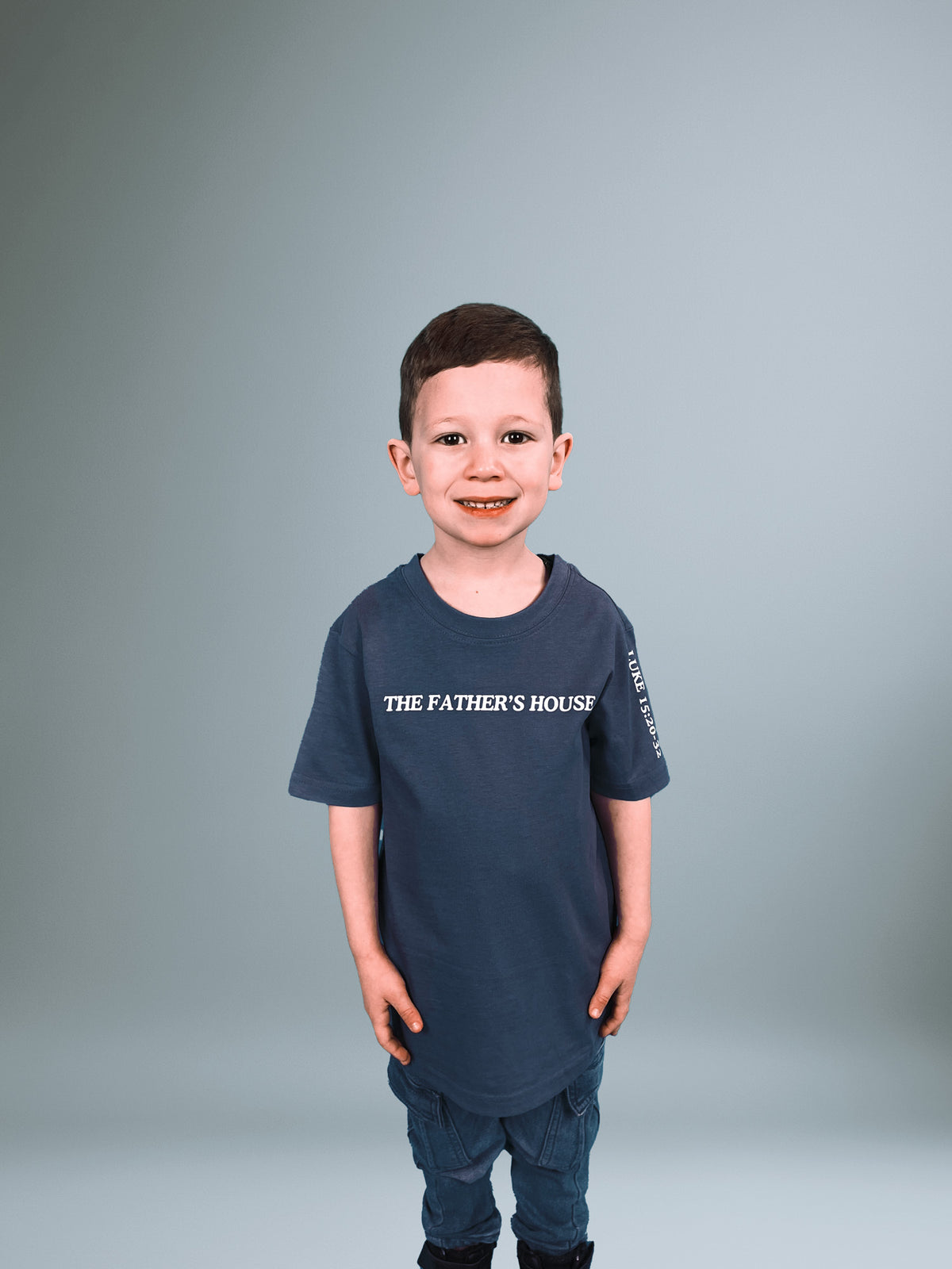 Junge im blauen Father's House Kindershirt, Vorderseite