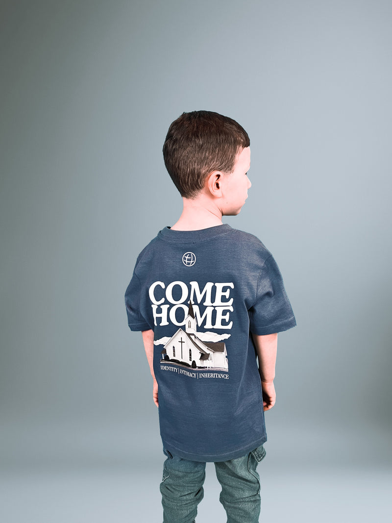 Kind von hinten im blauen Come Home T-Shirt