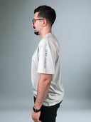 Mann im hellgrauen Father's House Shirt von der Seite, Lukas 15,20-32 auf dem Ärmel