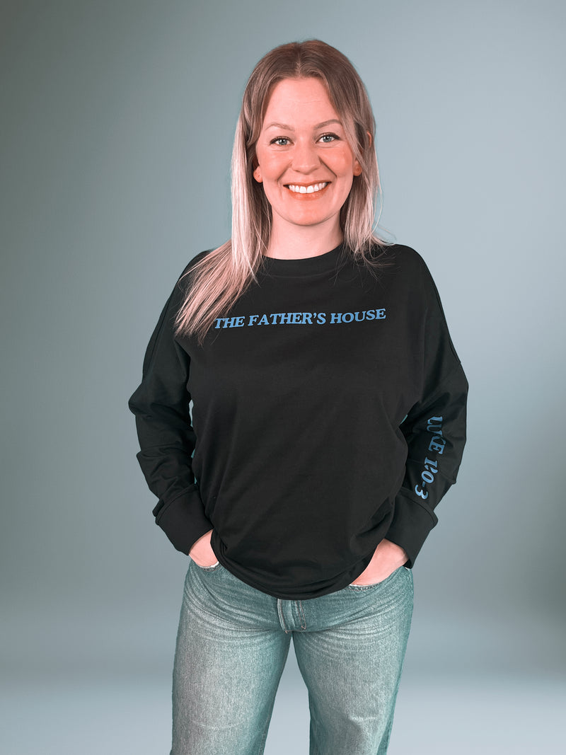 Frau im schwarzen Father's House Longsleeve, Vorderseite